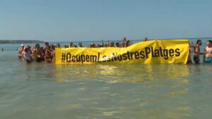 I manifestanti contro il sovraffollamento turistico prendono possesso della famosa spiaggia di Maiorca chiedendo controlli sul numero di visitatori