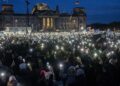 Affluenza di massa durante il fine settimana di proteste anti-estrema destra in Germania 42 People hold up their cell phones as they protest against the AfD party and right-wing extremism in front of the Reichstag building in Berlin