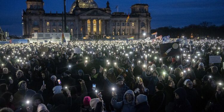 Affluenza di massa durante il fine settimana di proteste anti-estrema destra in Germania 35 People hold up their cell phones as they protest against the AfD party and right-wing extremism in front of the Reichstag building in Berlin