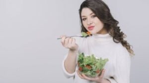 Una donna che mangia una ciotola di insalata