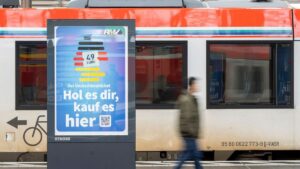 A man passes by an advertising for the Deutschlandticket (Germany Ticket) at a train station in Frankfurt, Germany, Monday, May 1, 2023.