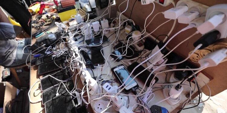 I palestinesi fanno affidamento sui pannelli solari in mezzo ai tagli all’elettricità per parlare con amici e familiari 35 Cellphones connected to electricity suppliers to charge them from solar panels.