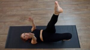 Una donna che fa il sollevamento della gamba dritta