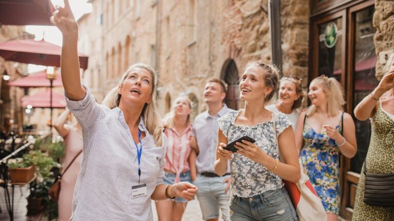 Women enjoy a tour through the city streets of Volterra, Italy
