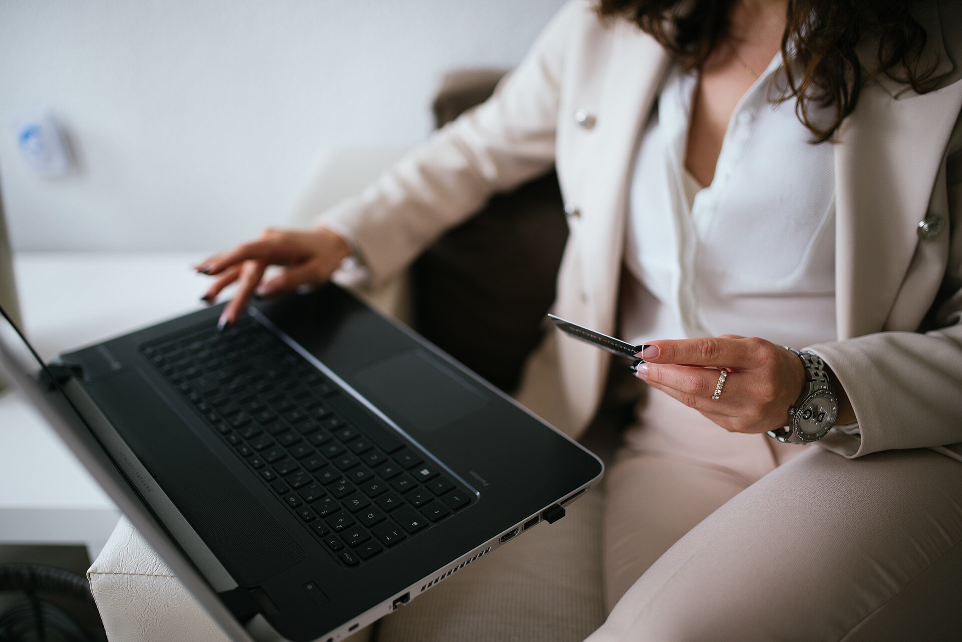 Black Friday 2026: quanto spendono gli italiani e cosa compreranno 1 Donna seduta alla scrivania con un computer portatile e una carta di credito in mano durante un acquisto online