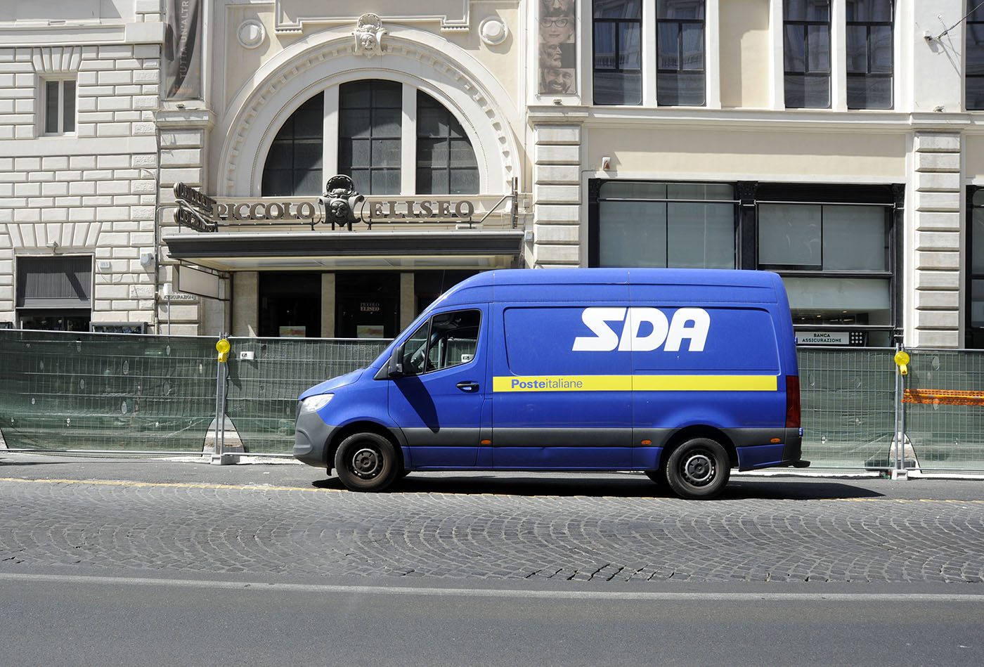 Furgone blu del corriere SDA di Poste Italiane parcheggiato in una strada del centro di Roma