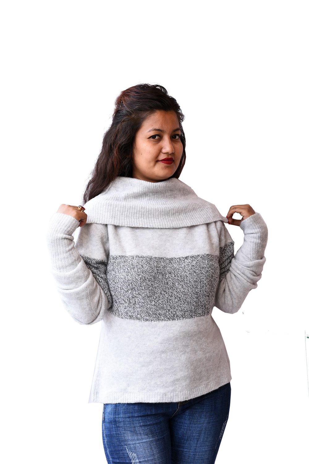 Donna che indossa un maglione grigio in cashmere a collo ampio abbinato a un paio di jeans